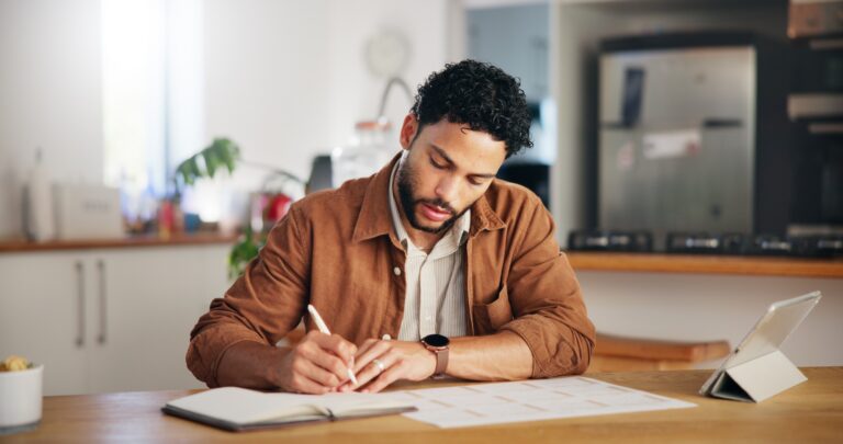 Man, writing and calendar planning in home with tablet agenda, priority checklist and time manageme
